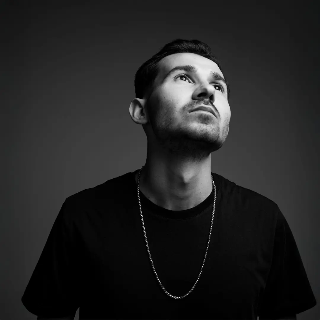 Müzisyen güneş gözlüklü close-up portre, yukarı bakış, koyu gri arka plan — İzmir spotify albüm kapağı fotoğrafı