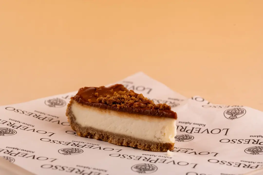 LovePresso karamel cheesecake dilimi bisküvi kırıntısı markalı kağıt, turuncu gradient fon — İzmir cafe tatlı fotoğraf çekimi, Mert Akdurak