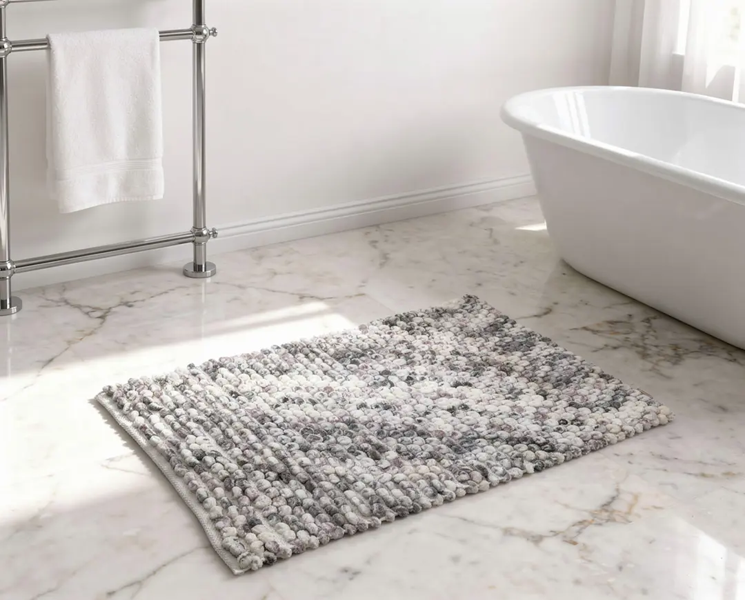 Enmore Tekstil gri-beyaz mermer desenli pom-pom pamuklu banyo paspası, Adobe Firefly Flux ile lüks banyo ortamına yerleştirilmiştir — kaynak görsel Nikon Z 7II 43MP İzmir RF Studio