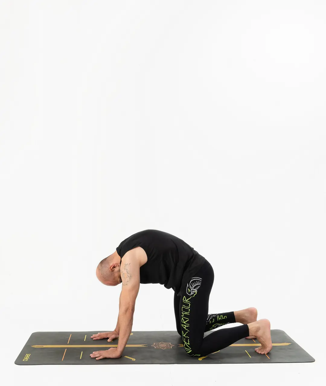 İzmir stüdyo ortamında erkek yoga eğitmeninin kedi duruşunda sırtını yuvarladığı Kentli Gurular yoga fotoğraf çekimi.