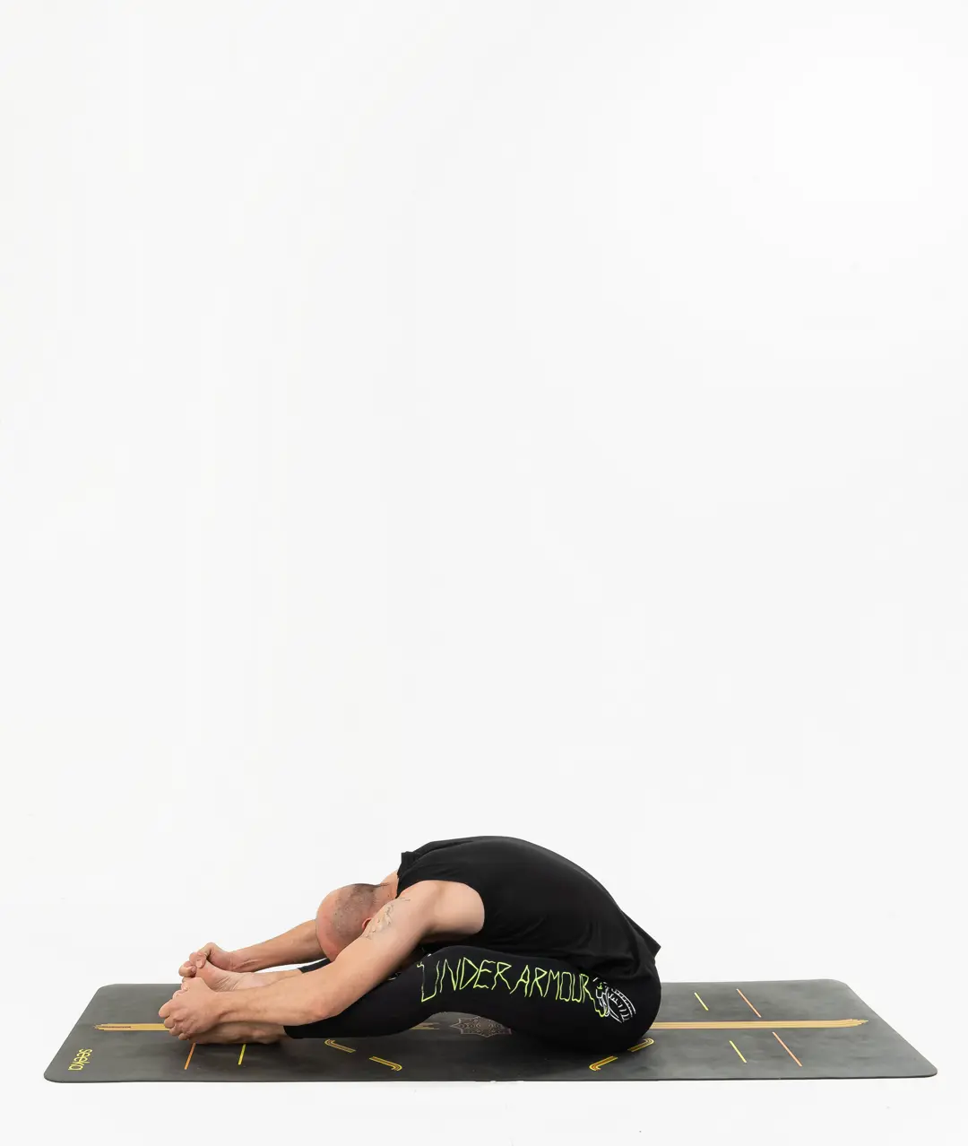 İzmir stüdyo matında erkek eğitmenin oturarak öne katlanma duruşunu uyguladığı Kentli Gurular yoga fotoğraf çekimi.