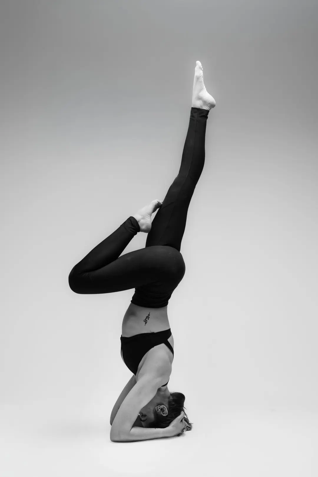 İzmir'deki fotoğraf stüdyosunda dramatik siyah beyaz ışıkla çekilen, yogawithmelis eğitmeninin zorlu yoga asana pozu.