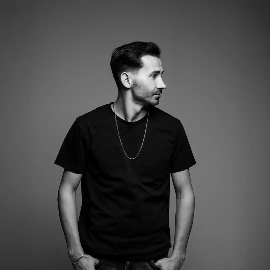Yasin Göncü tam boy siyah beyaz müzisyen portresi, siyah tişört, zincir kolye, sola bakış — İzmir RF Studio spotify albüm kapağı fotoğrafı