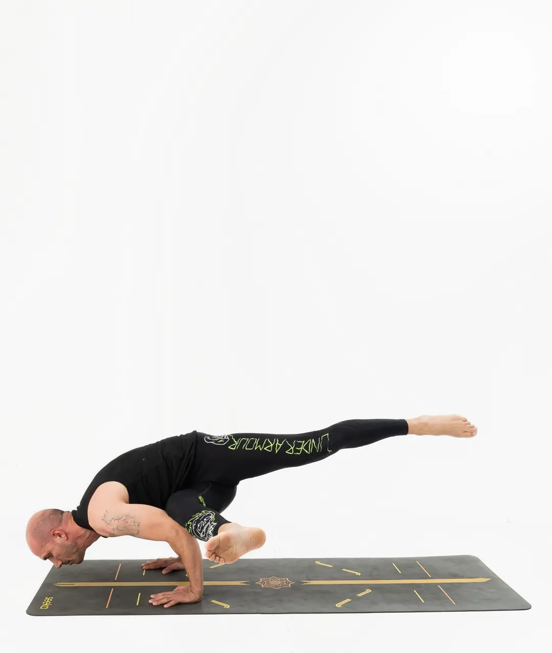 İzmir stüdyoda erkek eğitmenin uçan güvercin kol dengesinde bacağını uzattığı Kentli Gurular yoga fotoğraf çekimi.