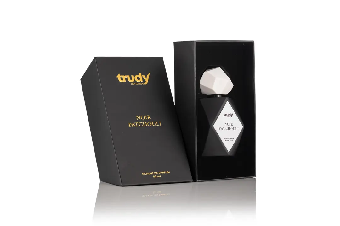 Mat siyah kutusu ve beyaz geometrik kapaklı şişesiyle Trudy Noir Patchouli modelinin beyaz fonda parfüm ürün fotoğrafı.